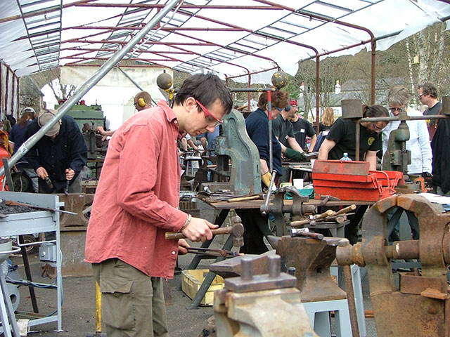 Blacksmiths working on their designs at the Forge In event at Kielder Castle.
